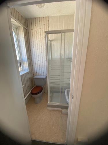 a bathroom with a toilet and a glass shower at Crosby Hotel in Blackpool