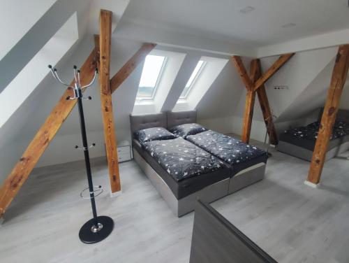 Zimmer im Dachgeschoss mit 2 Betten und einer Lampe in der Unterkunft Apartmány Pihel s parkovaním zdarma 