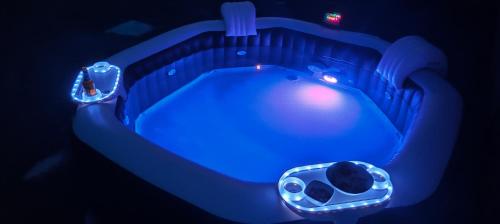 a blue lighted bath tub in a dark room at Les Gîtes de JueVince in Issac