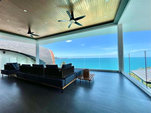 a living room with a couch and a ceiling fan at 苏梅岛观景台海景別墅Golden Coconut Villa 5 超级海景 私密泳池 接送服务 in Koh Samui 