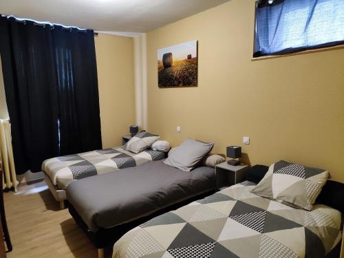JusseyにあるHOTEL DE LA GAREのベッド3台とソファが備わる部屋