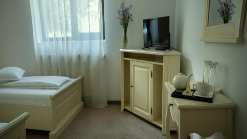 a small bedroom with a bed and a tv at Pensiunea Poiana Izvoarelor in Vatra Dornei