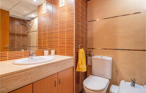 La salle de bains est pourvue de toilettes, d'un lavabo et d'un miroir. dans l'établissement Cozy Apartment In Roquetas De Mar With Kitchen, à Roquetas de Mar
