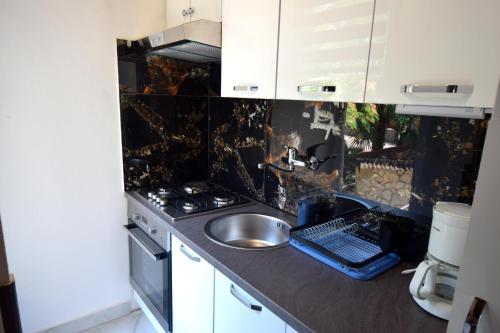 Il comprend une petite cuisine équipée d'un évier et d'une cuisinière. dans l'établissement Apartment Potnar Z, à Malinska