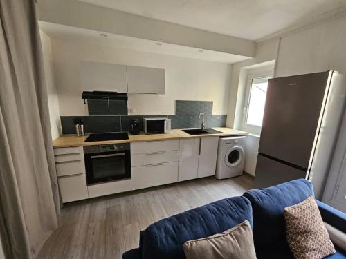 - une cuisine avec des appareils électroménagers blancs et un canapé bleu dans l'établissement Atlas - Era, à Béziers
