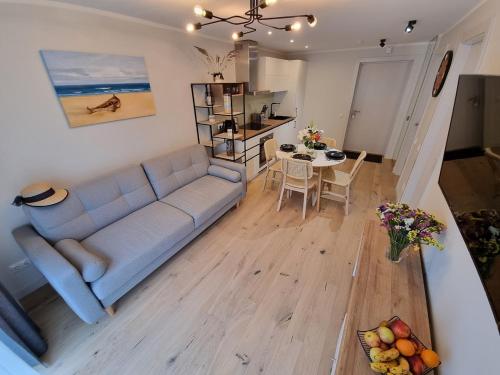 a living room with a blue couch and a table at Angren Albatross, SEA & SPA in Ķesterciems