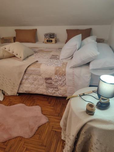 a bedroom with two beds and a table with a lamp at Casa da Rapadoira in Laxoso de Abaixo