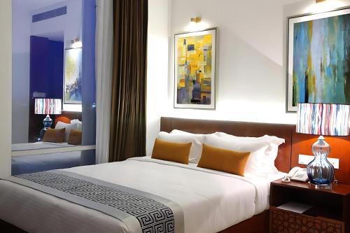 a bedroom with a large bed and a bathroom at Empyrean Dhaka City Centre in Dhaka