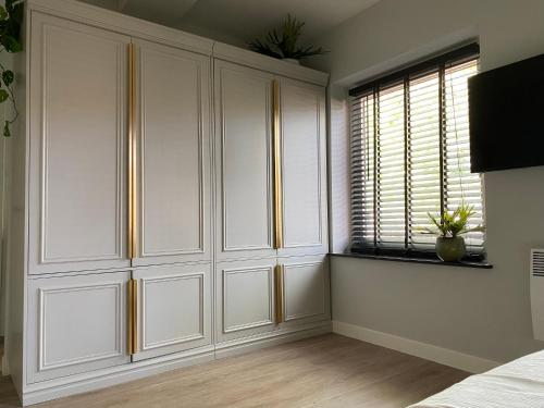 a bedroom with white cabinets and a window at Suite Spot Houten in Houten