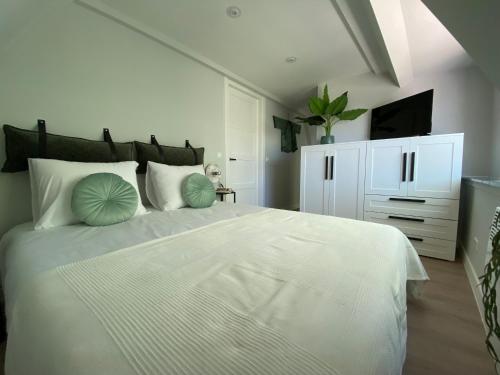 a bedroom with a large white bed with green pillows at Suite Spot Houten in Houten