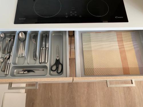 a drawer with utensils in a kitchen under a microwave at Suite Spot Houten in Houten
