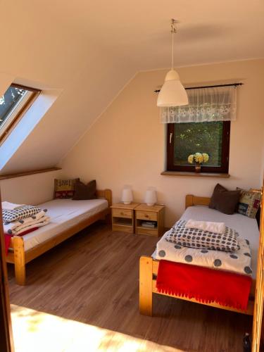 Schlafzimmer im Dachgeschoss mit 2 Betten und einem Fenster in der Unterkunft Dom w Rzeczce Góry Sowie in Rzeczka