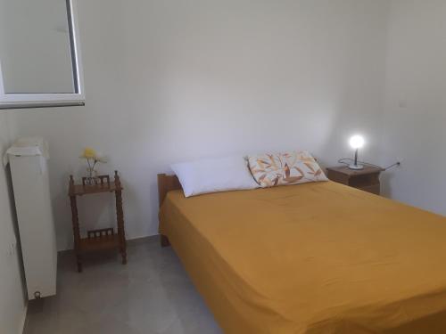 1 dormitorio con 1 cama con colcha amarilla en Vagelis Nemea apartments, en Neméa