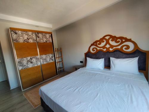 a bedroom with a large bed with a wooden headboard at Gala Otel Edirne in Edirne