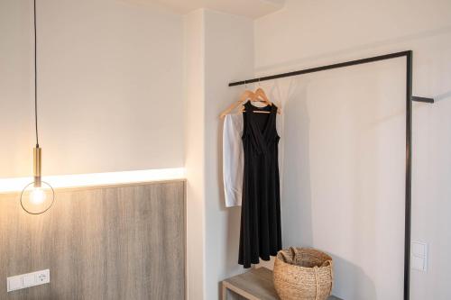 a black dress is hanging on a rack in a room at Yenesis Seaside Retreat - Adults only over 15 in Tinos Town