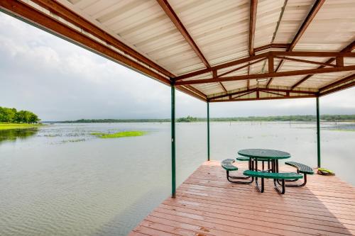 a table and chairs on a dock with water at Lake Fork Studio Cabin with Dock and Boat Ramp! in Emory