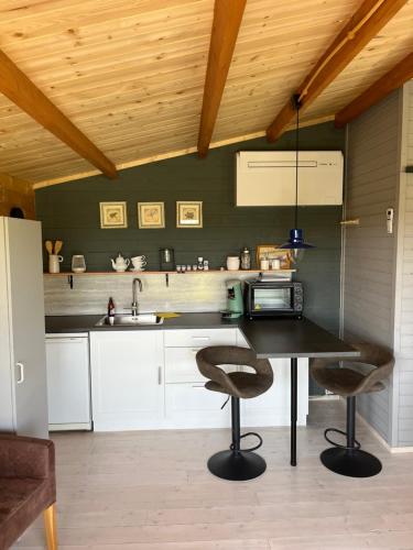 a kitchen with a table and two bar stools at Fields 1216 in Zwaanshoek