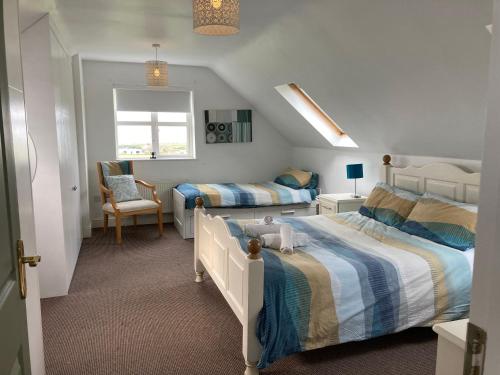 a bedroom with two beds and a chair at Wild Atlantic View in Sligo