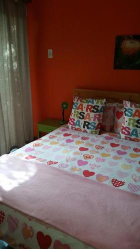 a bed in a bedroom with a bedspread with hearts at Cape Agulhas BACKPACKERS in Struisbaai