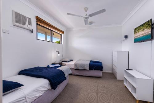 a bedroom with two beds and a ceiling fan at Zion Escapes Retreat on Pease, City Edge Family Apartment in Westcourt