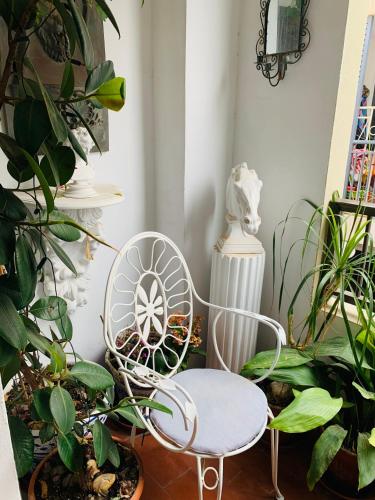 una silla blanca en una habitación con plantas en Casa Spencer, en Benidorm