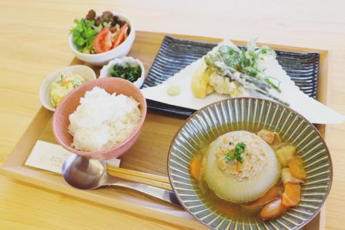 Guest House「さごんヴィレッジ」 في تسوشيما: صينية طعام عليها رز وخضروات