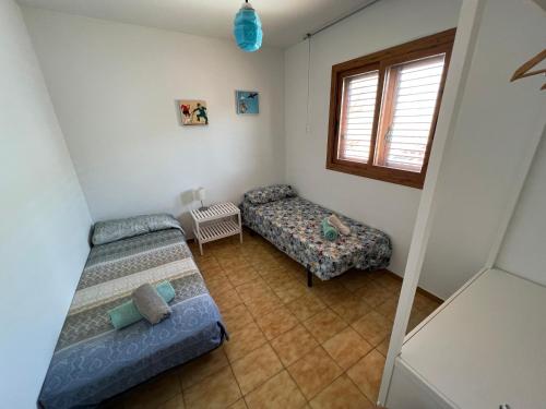 een kleine kamer met 2 bedden en een raam bij El Xalet d’en Joan Maria d’Altafulla in Altafulla