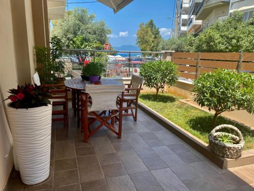 patio ze stołem i krzesłami na balkonie w obiekcie Harmony by the Sea w Chalkidzie