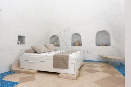 a bedroom with a white bed and mirrors on the wall at Trullo Gallipoli Punta Pizzo in Pizzo
