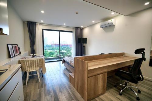 una camera con scrivania e una cucina con tavolo di Lovely Design Studio in Vinhomes D'capitale Trần Duy Hưng a Hanoi