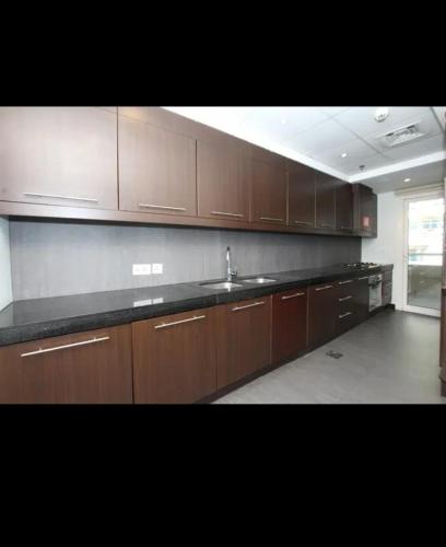 a kitchen with wooden cabinets and a counter top at Lady's bedspace in Dubai