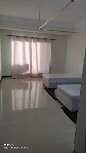 ein leeres Zimmer mit 2 Betten und einem Fenster in der Unterkunft Lady's bedspace in Dubai