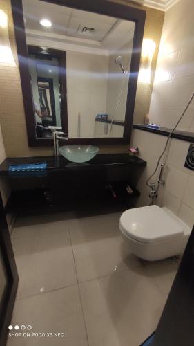 ein Badezimmer mit einem Waschbecken, einem WC und einem Spiegel in der Unterkunft Lady's bedspace in Dubai