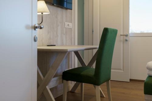 a kitchen with a table and a green chair at Ca' Barbieri San Donà in San Donà di Piave
