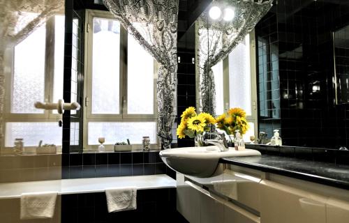 - une salle de bains en noir et blanc avec lavabo et miroir dans l'établissement Lily's House CAMPO DE FIORI, à Rome