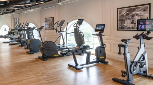 a gym with a row of exercise bikes and treadmills at 21 High Street Residence By The Torch in Doha