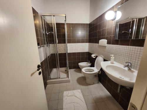 een badkamer met een douche, een toilet en een wastafel bij Casa cecchi siena in Siena