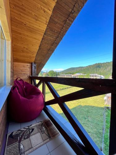 a red pillow sitting on a balcony with a window at Приват-котедж Зарінок in Mykulychyn