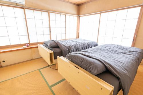 two twin beds in a room with windows at 南伊豆　貸別荘　夜空の星 in Minamiizu
