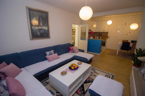 a living room with a blue and white couch at Apartman Flumen in Mostar