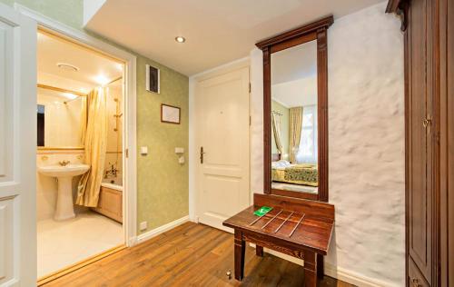 a bathroom with a wooden table and a mirror at Taanilinna Hotell in Tallinn