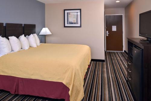 a hotel room with a bed and a flat screen tv at Wingate by Wyndham Beaver I-15 in Beaver