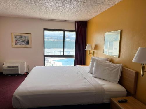 a hotel room with a large bed and a window at Motel 6 Pocatello ID in Pocatello