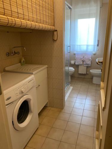 bagno con lavatrice e servizi igienici di AV Apartment ad Aci Castello