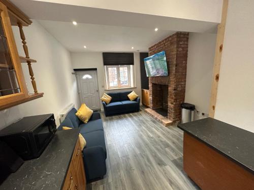 a living room with a blue couch and a fireplace at Newtown Townhouse in Newtown