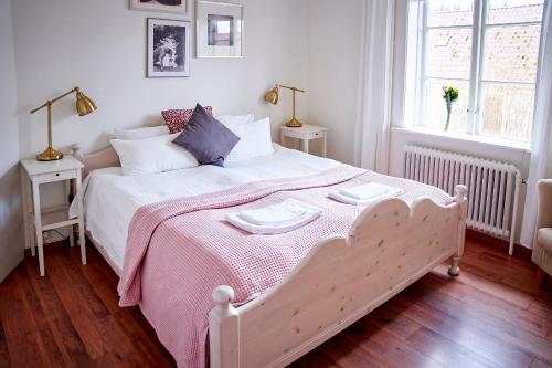 a bedroom with a white bed with a pink blanket at Borghamn Strand in Borghamn