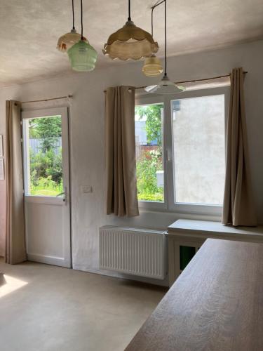 um quarto com duas janelas, uma secretária e uma mesa em 't Jaar 50 em Wortegem