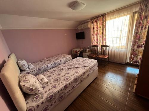 um quarto de hotel com uma cama e uma janela em Daniel Guest House em Nesebar