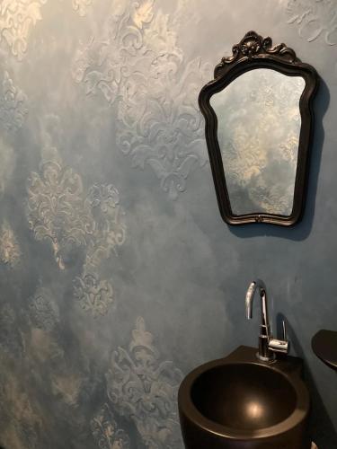 a bathroom with a sink and a mirror on a wall at 't Jaar 50 in Wortegem