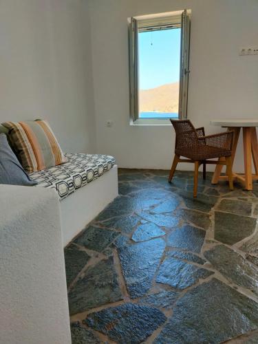 a room with a couch and a chair and a window at Amorgos Elegant Houses, 6 Villas in Amorgos